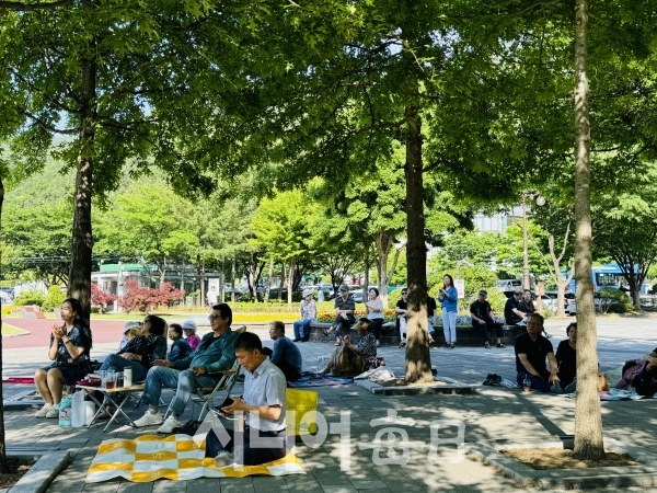 시원한 그늘에서 시민들이 버스킹을 즐기고 있다. 박미정 기자