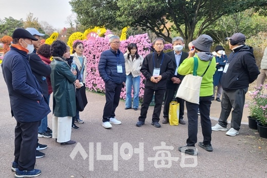 B조 지킴이들이 임태조 산림교육 전문 해설사의 국화꽃에 대한 해설을 듣고 있다.